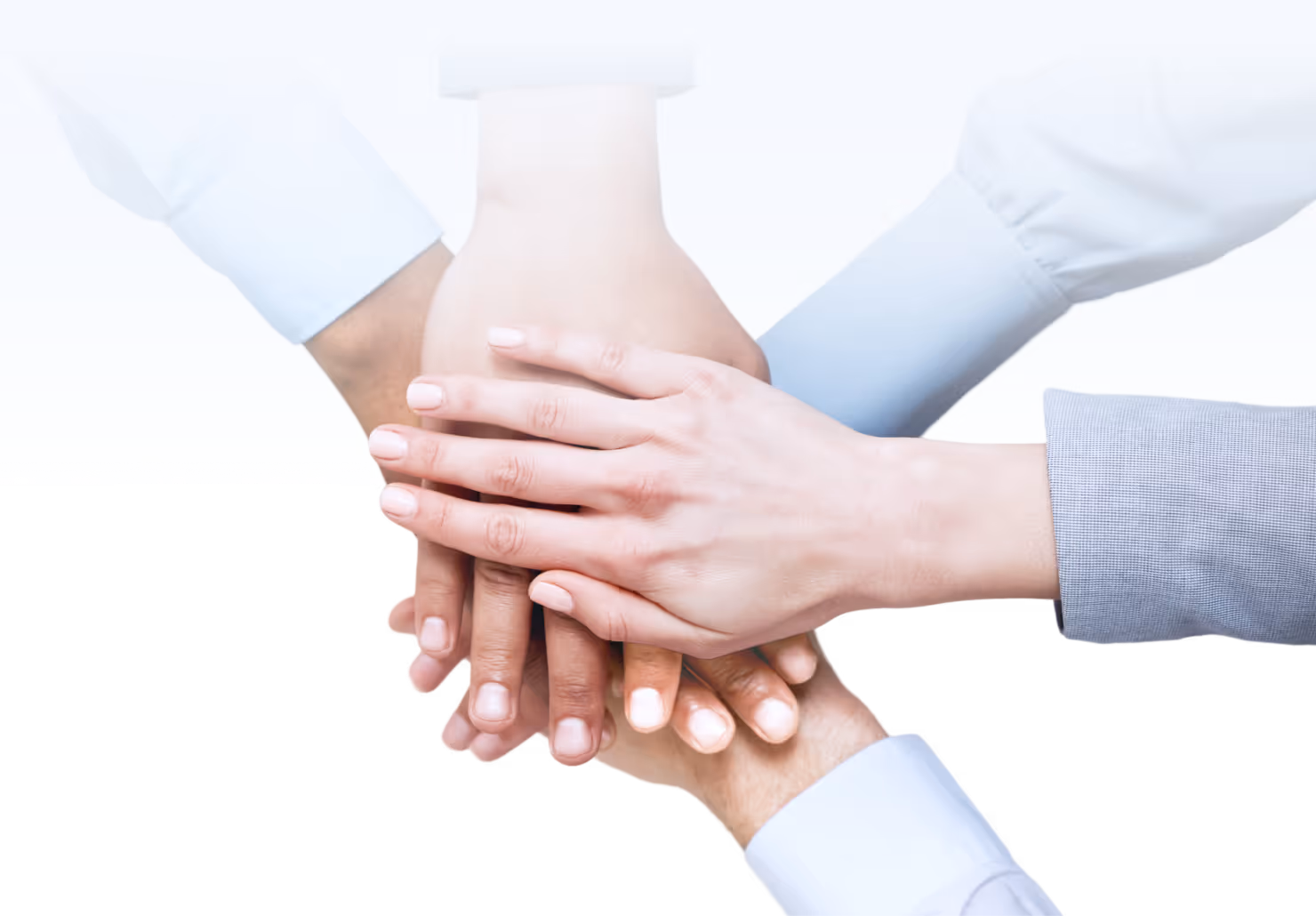 Four hands stacked together symbolizing teamwork and unity.