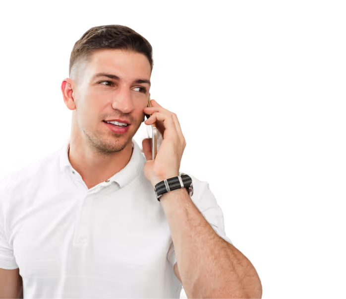 Young man in a white polo shirt talking on a smartphone while looking to the side.