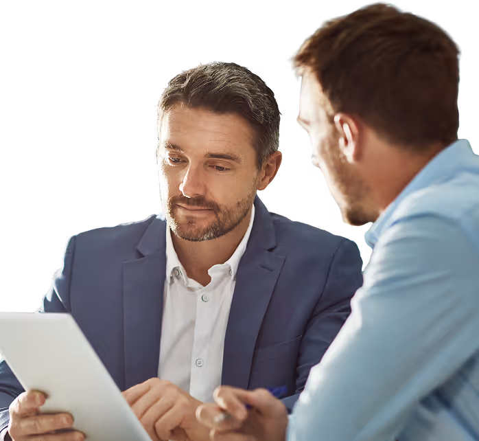 Two businessmen discussing a document, one in a blue suit and the other in a light blue shirt.
