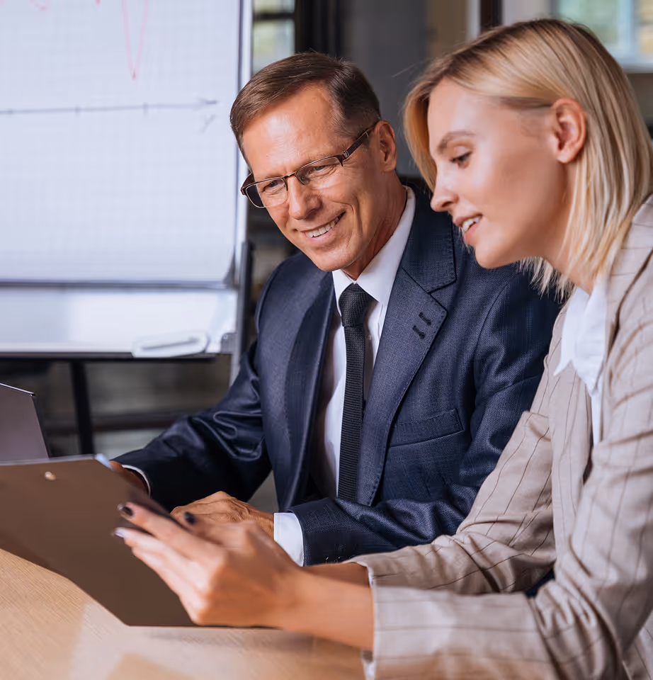 Businessman and businesswoman reviewing documents together in an office setting.