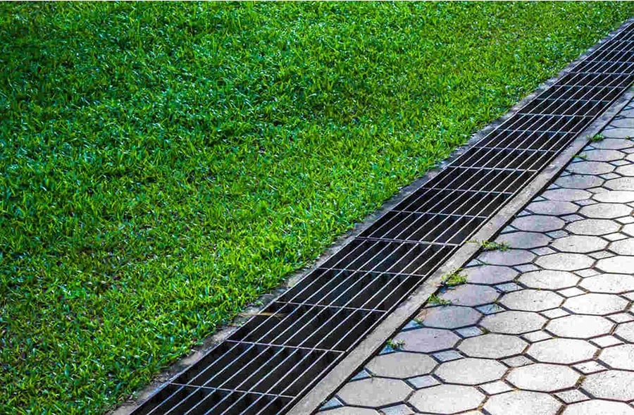 Metal trench drain along grassy area for surface water collection