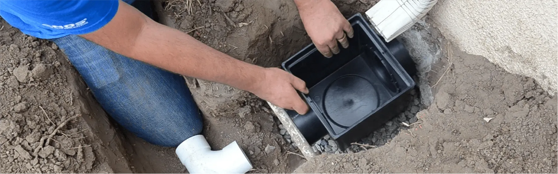 Decorative rock-filled trench drain for landscape water drainage