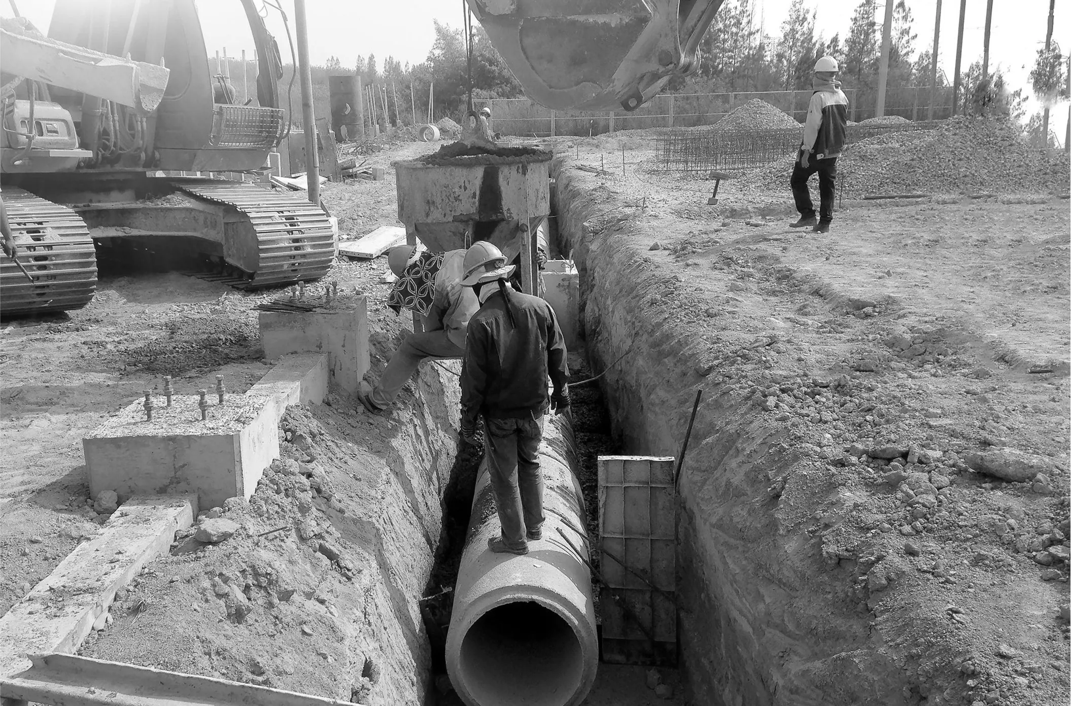 Worker placing drain basin in excavation for water redirection