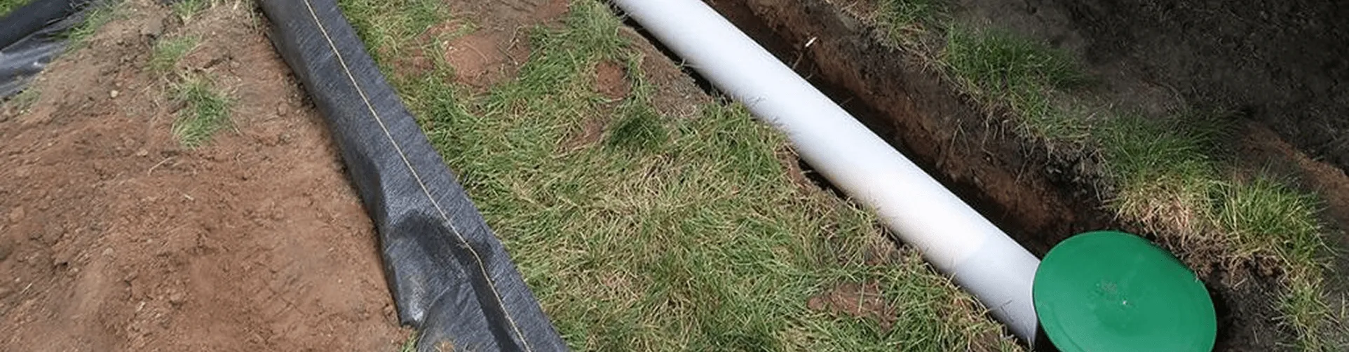 Technician inspecting and repairing clogged gutter downspout pipe