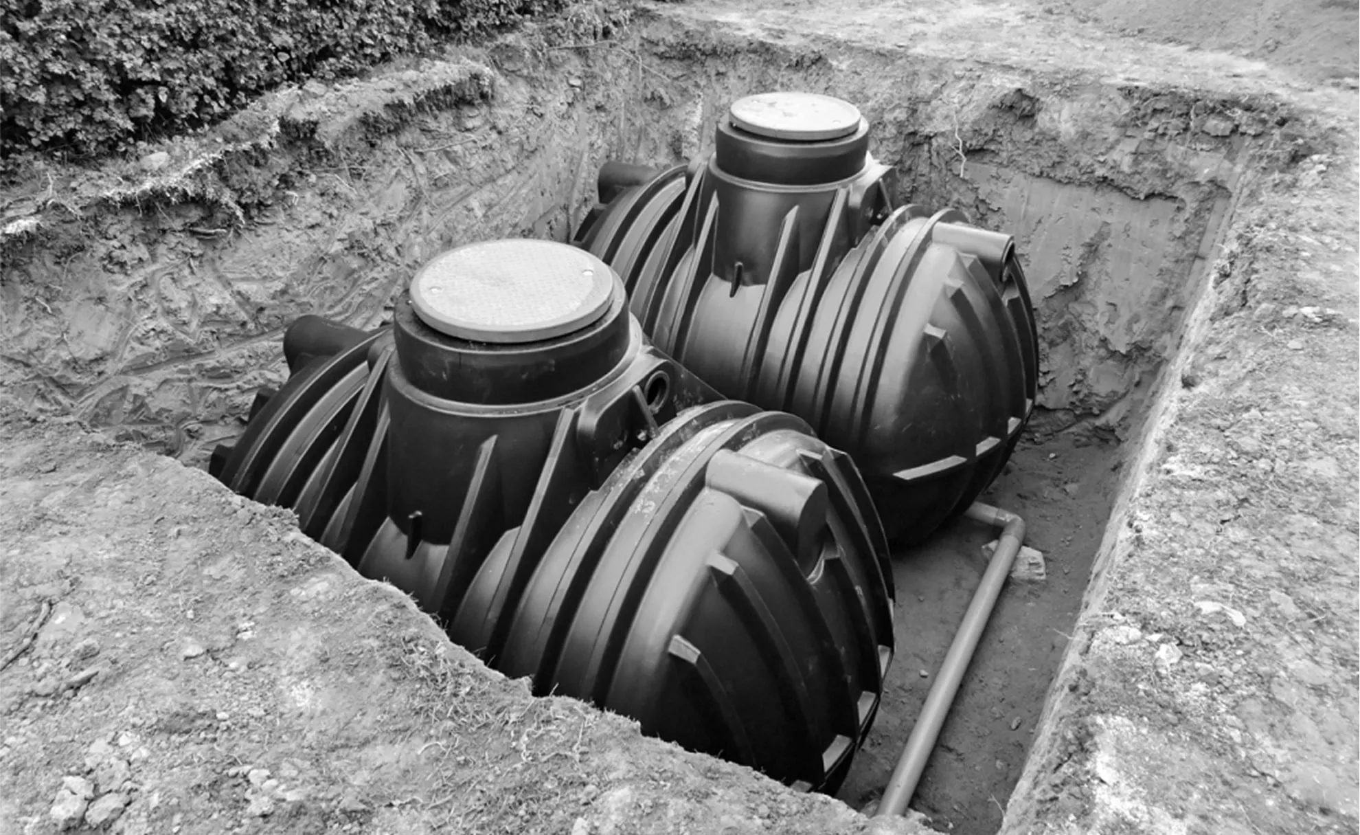 Construction crew installing drywell system at commercial site