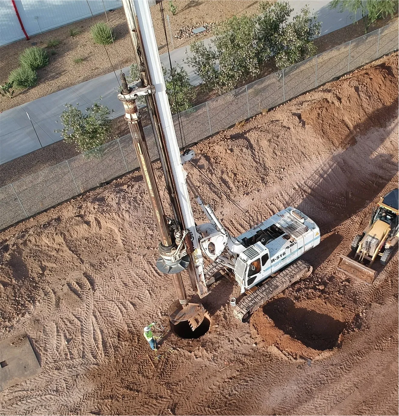Excavation site with heavy equipment preparing area for drywell installation
