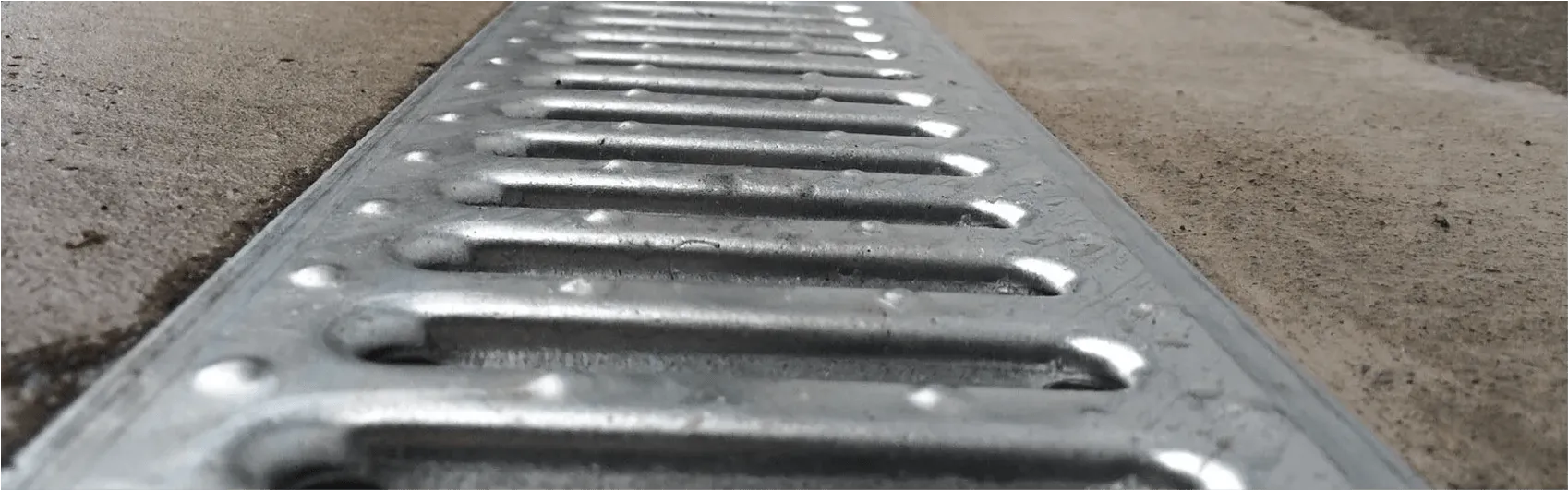 Slotted trench drain cover used for road or parking-lot drainage