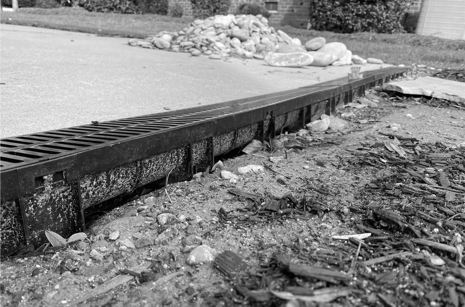 Black-and-white image of heavy-duty trench drain channel under construction