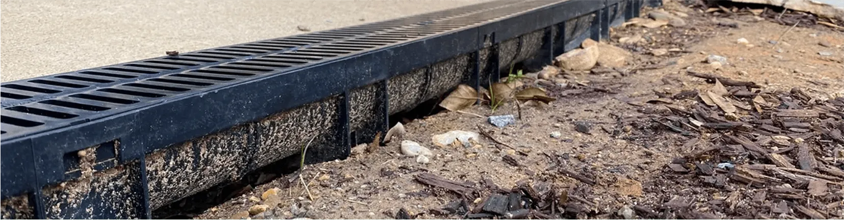 Linear trench drain installed along paved surface for efficient runoff control