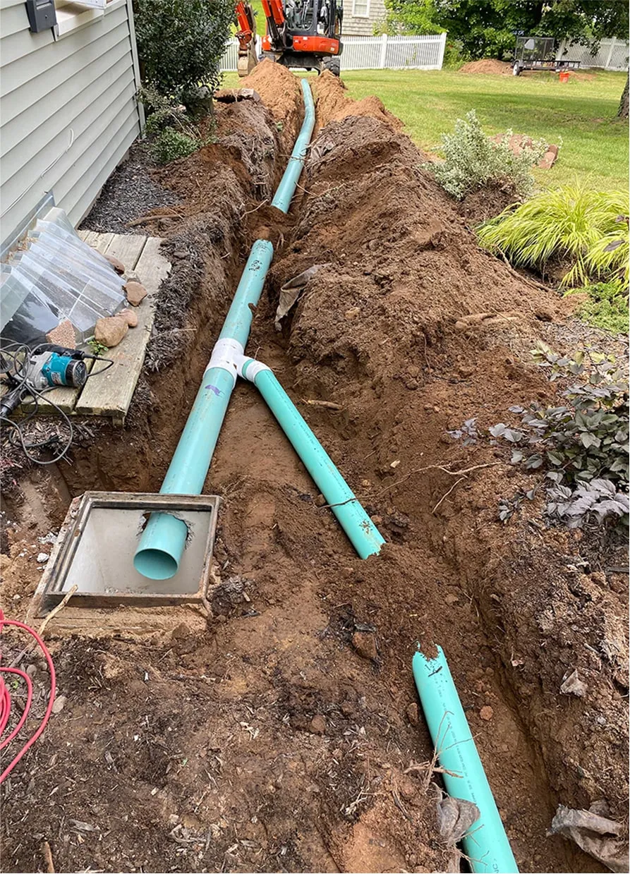 Blue pipes being installed in residential yard drainage system