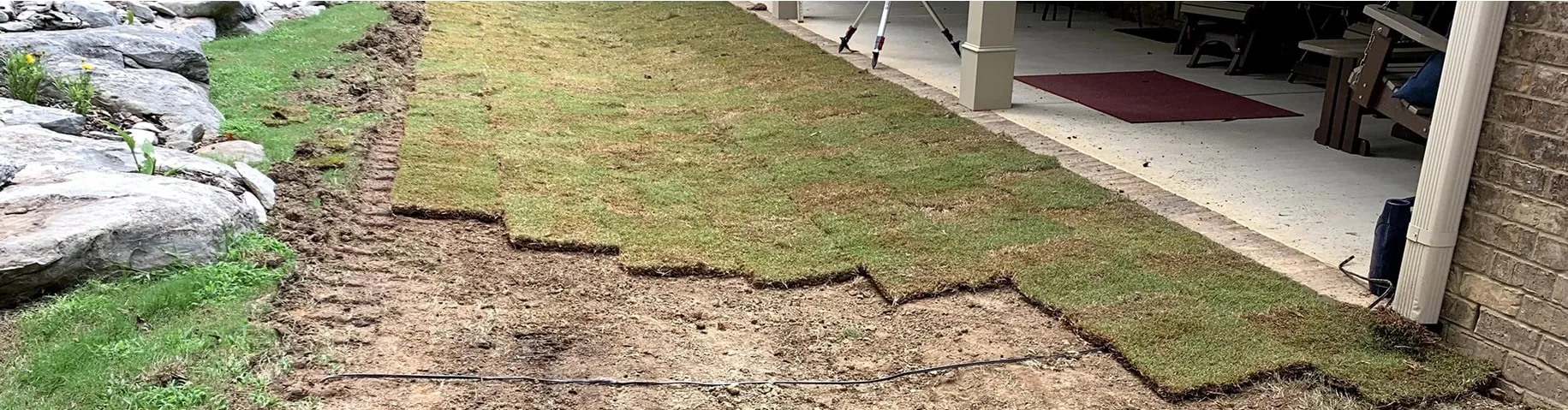 Yard drainage trench installation near garage area