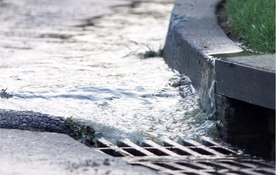 Driveway drainage system with stormwater grate and curb inlet