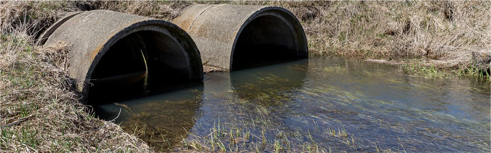 Dual culvert pipes allowing stormwater flow through embankment