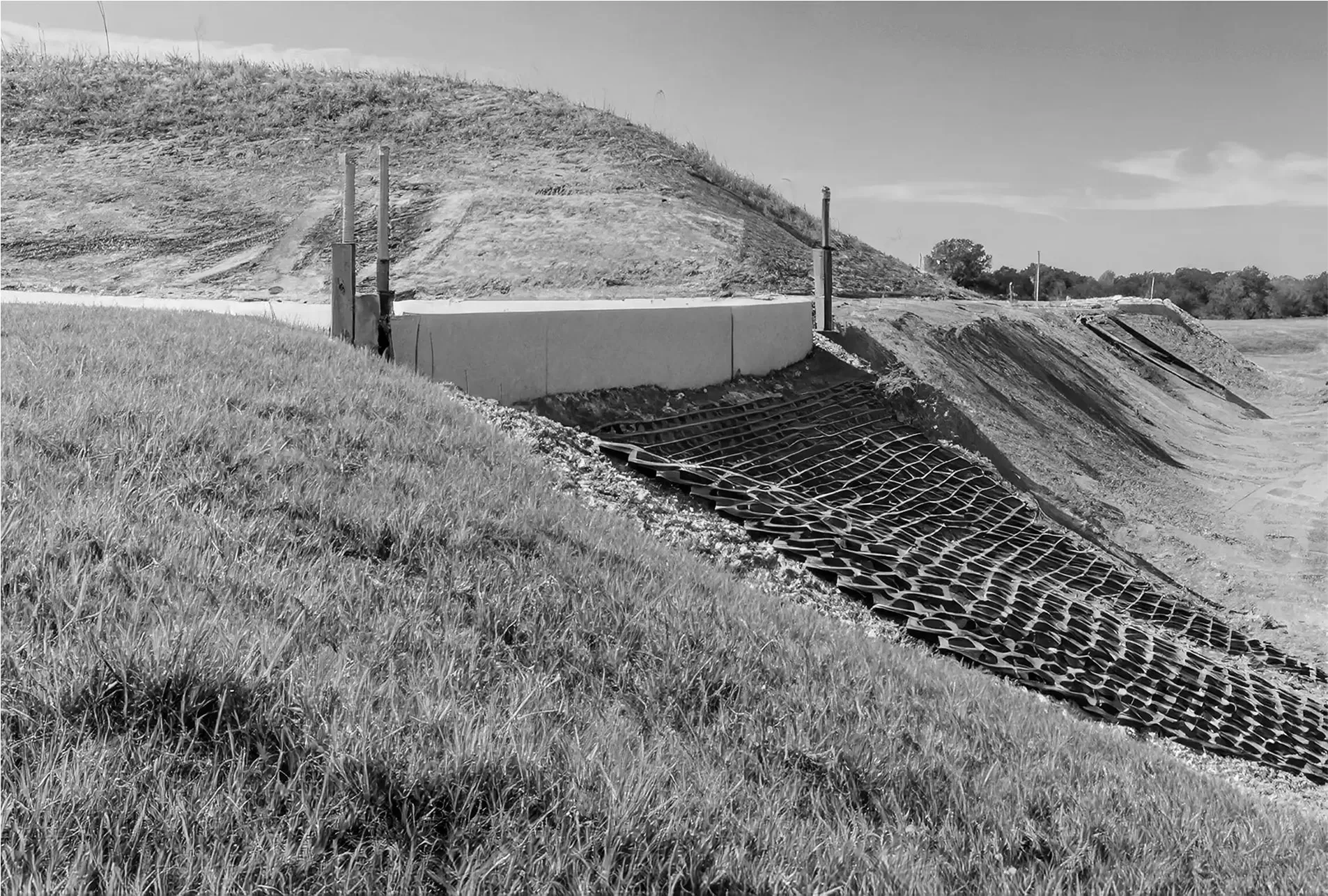 Black-and-white image of erosion-control barrier along hillside construction area