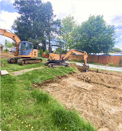Excavator preparing drainage trench at construction site