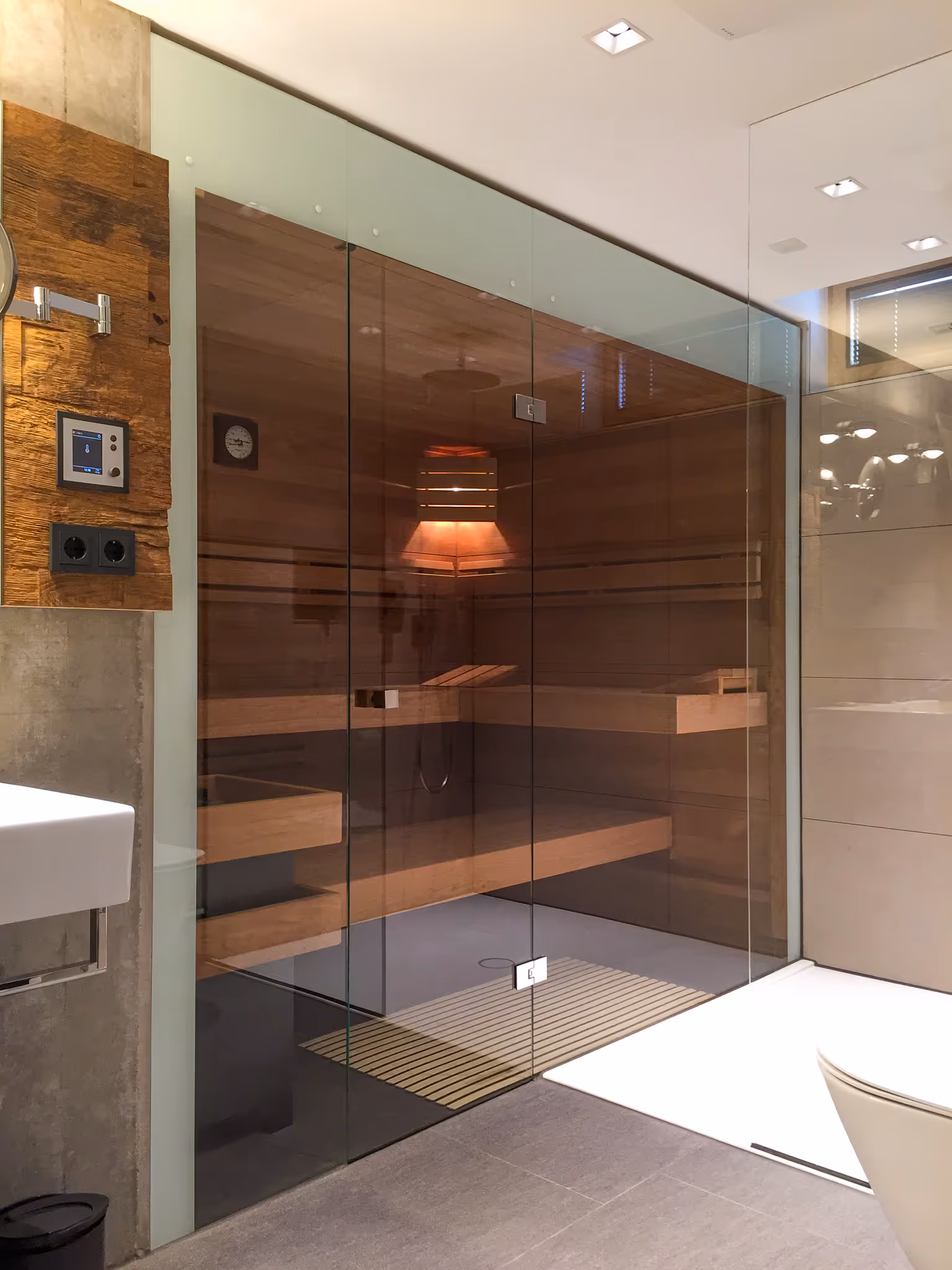 Moderne Innensauna mit Glasfront und Holzverkleidung – stilvolles Saunadesign im eigenen Badezimmer.