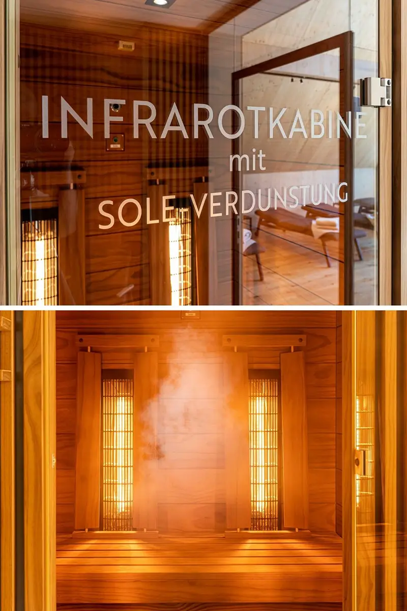 Nahaufnahme einer Infrarotkabine mit Soleverdunstung aus Holz, im oberen Bereich ist die beschriftete Glastür sichtbar, im unteren Bereich sieht man die beleuchtete Kabine und aufsteigenden Dampf.
