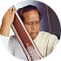 Older man carefully painting or marking a vertical wooden object against a white background.