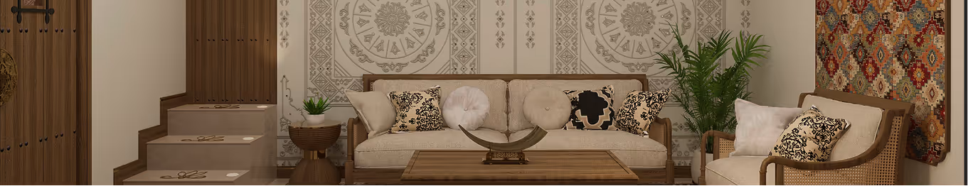 Cozy living room with beige sofa and chair, decorated with patterned cushions, wooden coffee table, side table with plant, and a colorful wall tapestry.