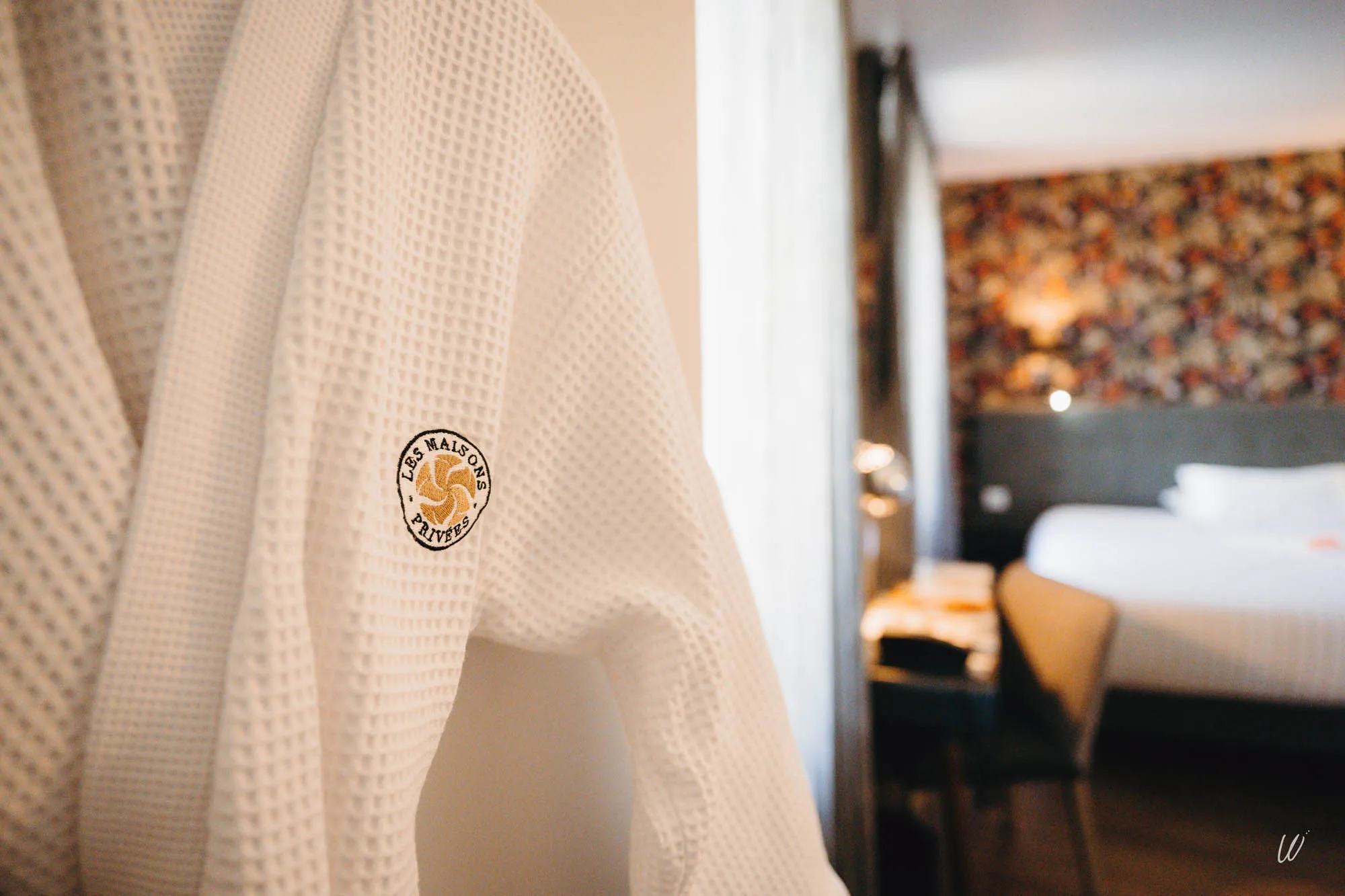 Détail d’un peignoir brodé “Les Maisons Privées” dans une chambre de l’hôtel Les Armes de Champagne, à L’Épine.