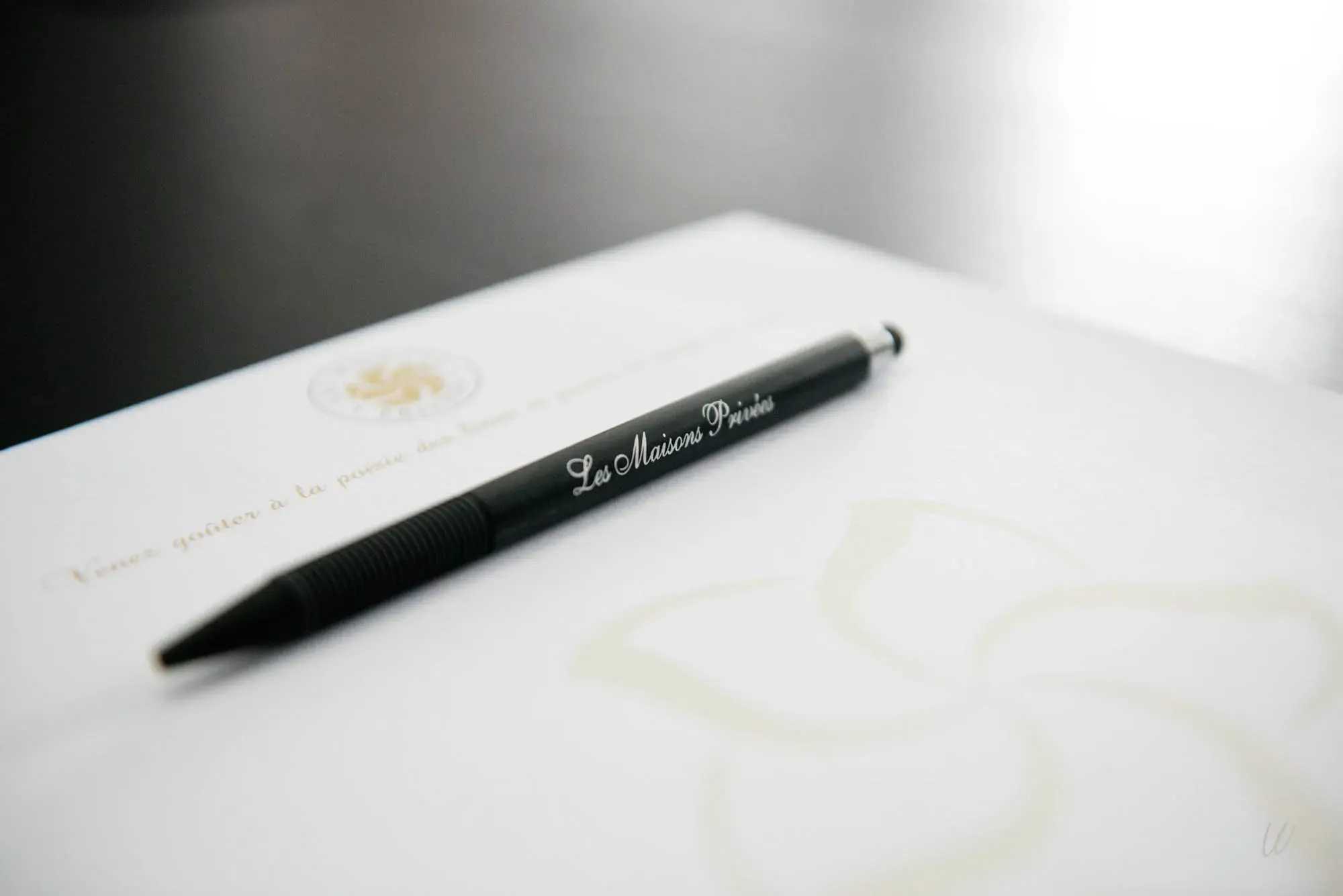 Stylo noir marqué « Les Maisons Privées » posé sur une feuille de papier à en-tête, préparé pour les réunions professionnelles à l’hôtel Armes de Champagne, membre du groupe Les Maisons Privées.