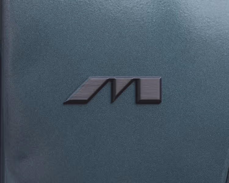 Black stylized M logo on a textured dark gray surface.