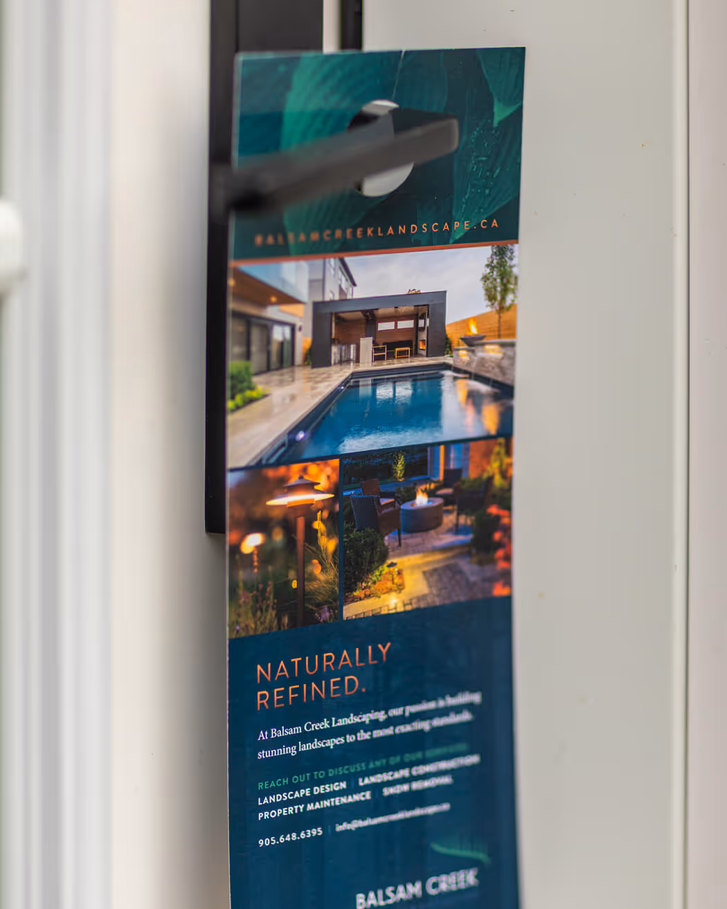 Door hanger advertising Balsam Creek Landscaping with images of a modern backyard pool, outdoor fire pit, and landscaping lighting.