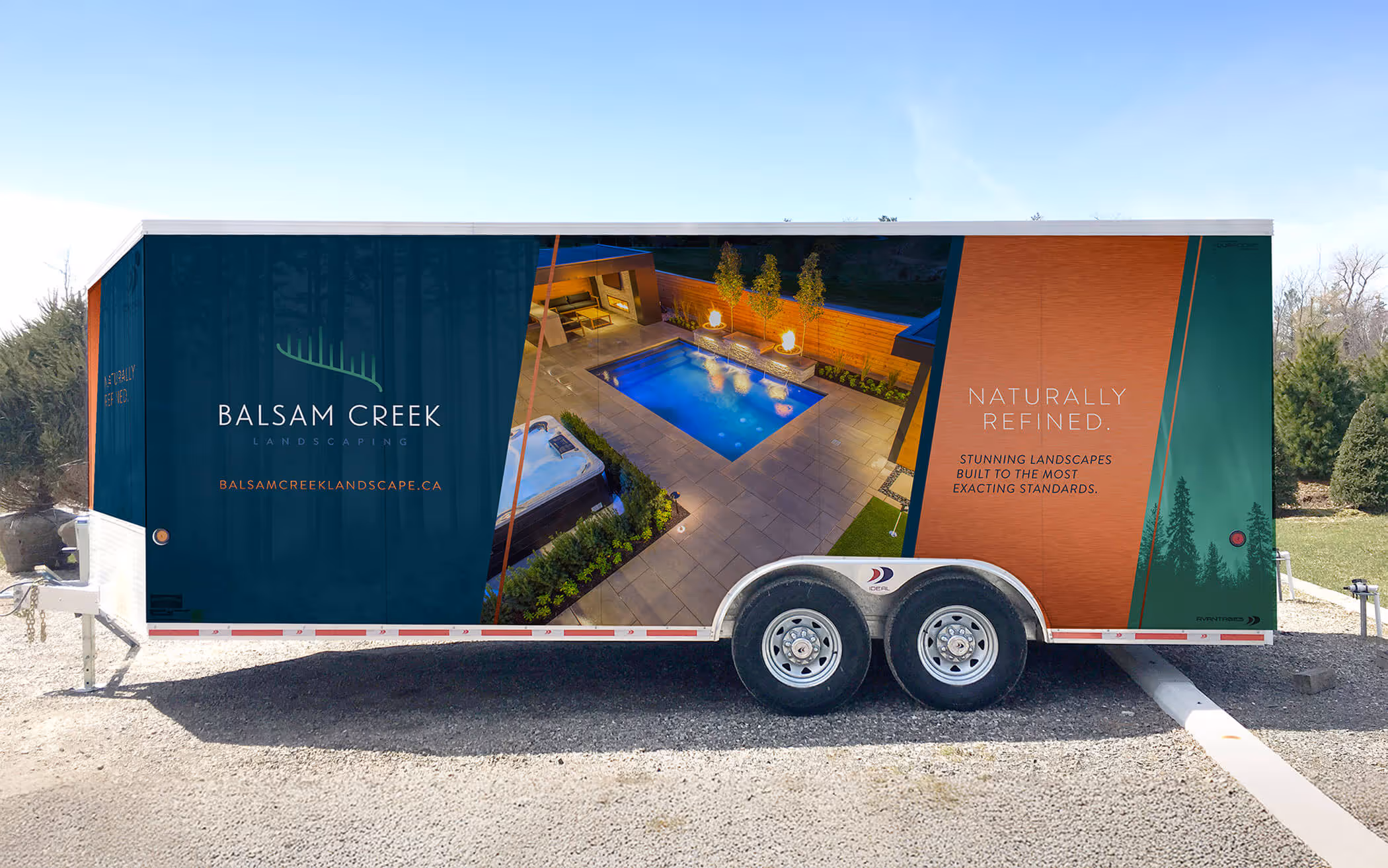 Trailer wrap advertising Balsam Creek Landscaping with a nighttime poolside patio and fire feature image, logo, and text reading 'Naturally Refined. Stunning landscapes built to the most exacting standards.'