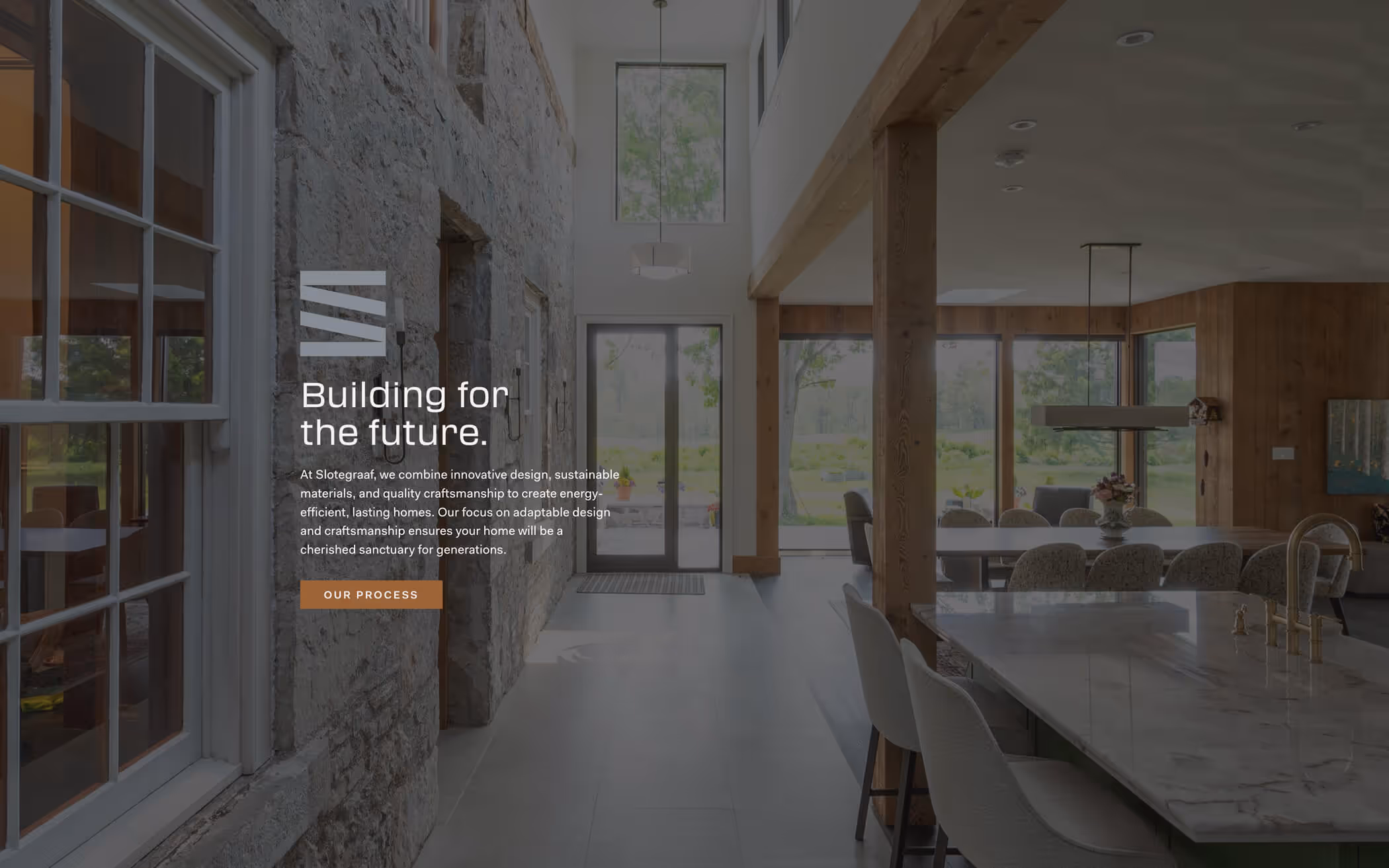 Modern open kitchen and dining area with large windows, stone wall, and wooden beams showcasing a spacious, light-filled home interior.