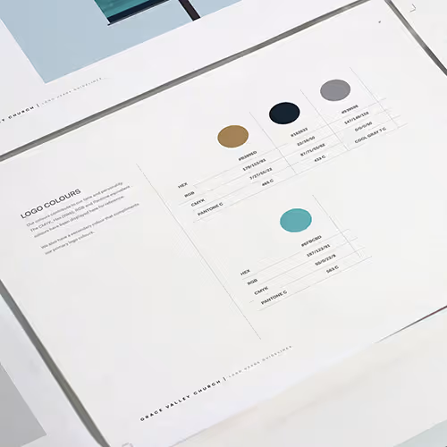 Printed brand guidelines showing logo colors with color swatches in brown, black, gray, and teal along with their HEX, RGB, CMYK, and Pantone values.