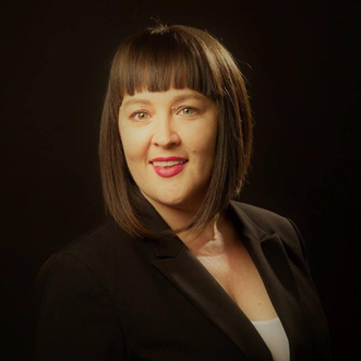 Headshot of Nichole R. Hanscom, COO at How to Manage a Small Law Firm, wearing black suit jacket and smiling.
