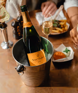 A bottle of white wine in a wine cooler on the table in the restaurant