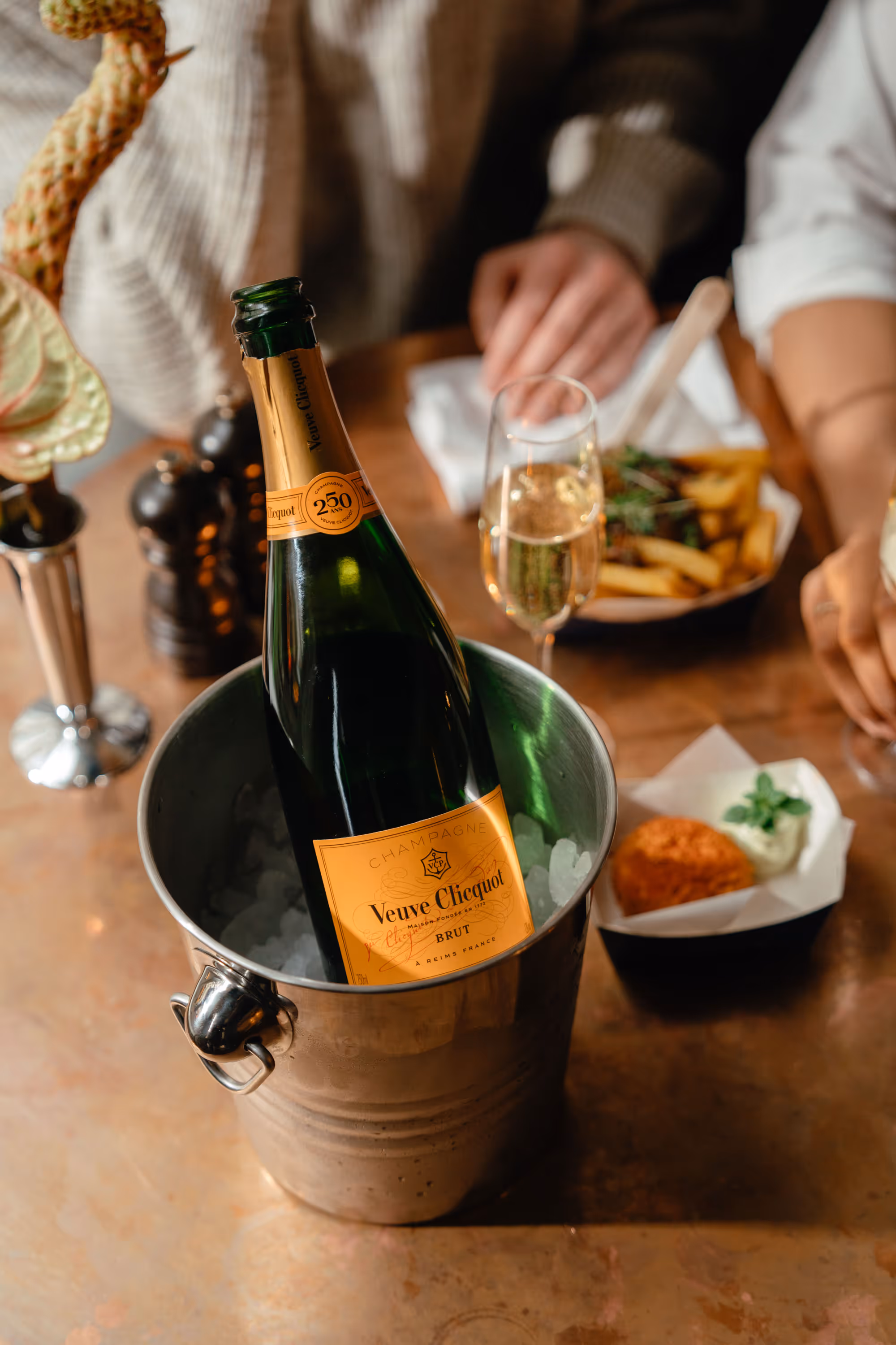 A bottle of white wine in a wine cooler on the table in the restaurant