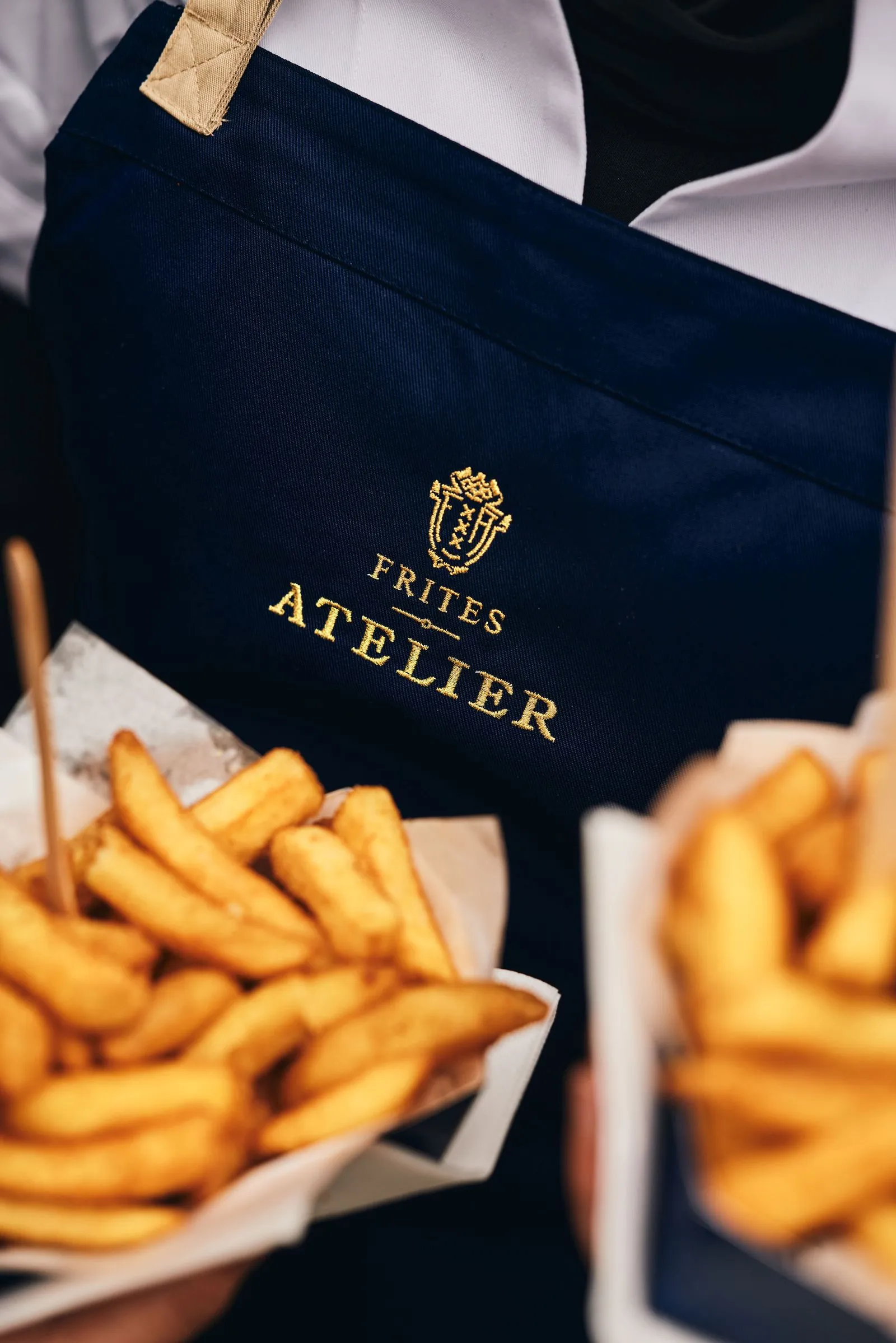 Employee holding 2 frites in his hands