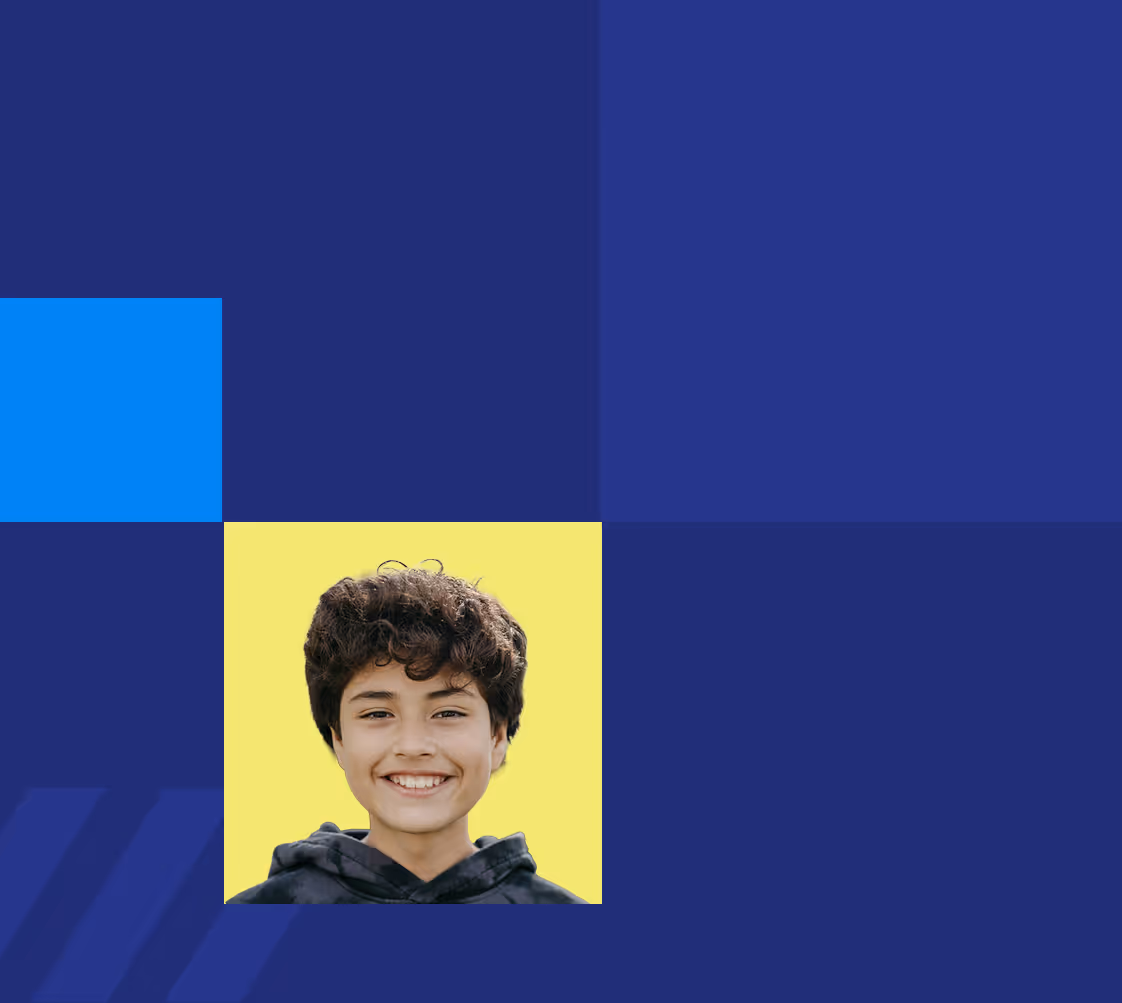 Smiling boy with curly hair wearing a dark hoodie against a yellow background with blue graphic squares.