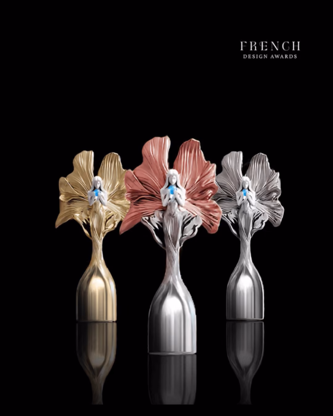 Three French Design Awards trophies in gold, bronze, and silver with a figure holding a blue star.
