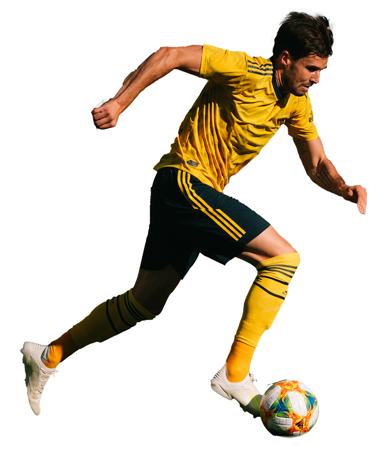 Clipped out image of a soccer player running with a soccer ball.