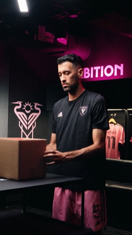 Image of Inter Miami CF player opening a box in the locker room.