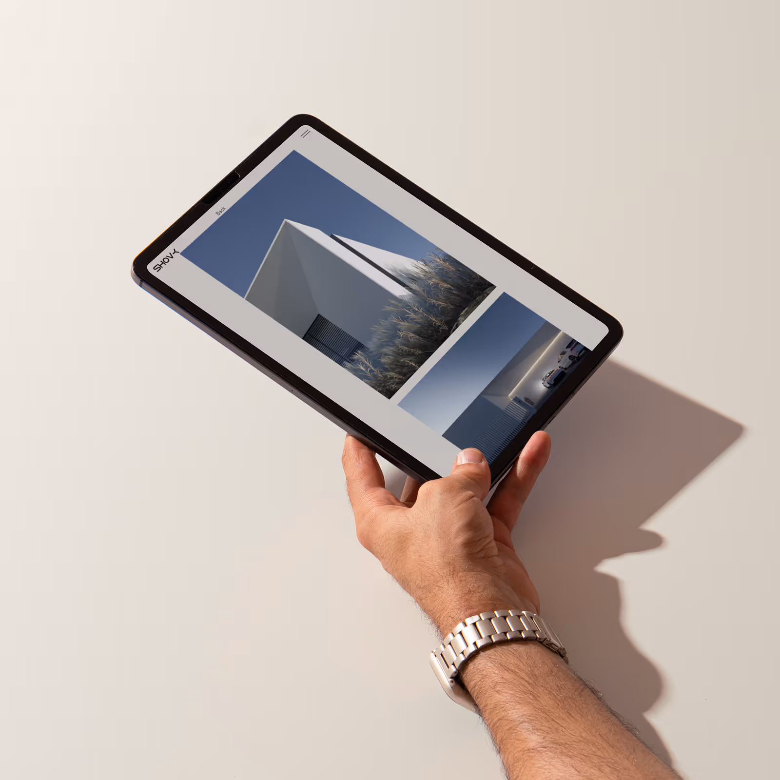 A man holding a tablet with a picture of a building on it.