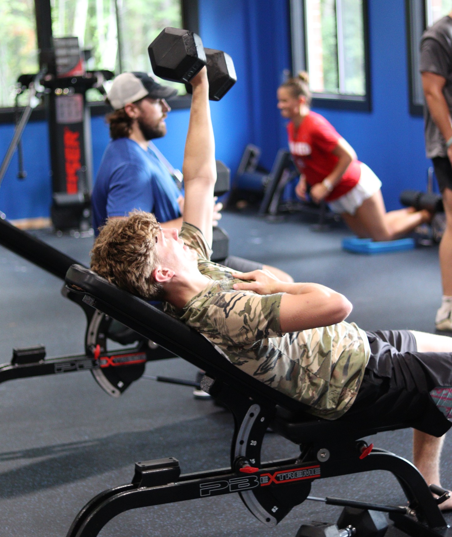 An athlete performing a dumbbell press at KBP in the new facility.