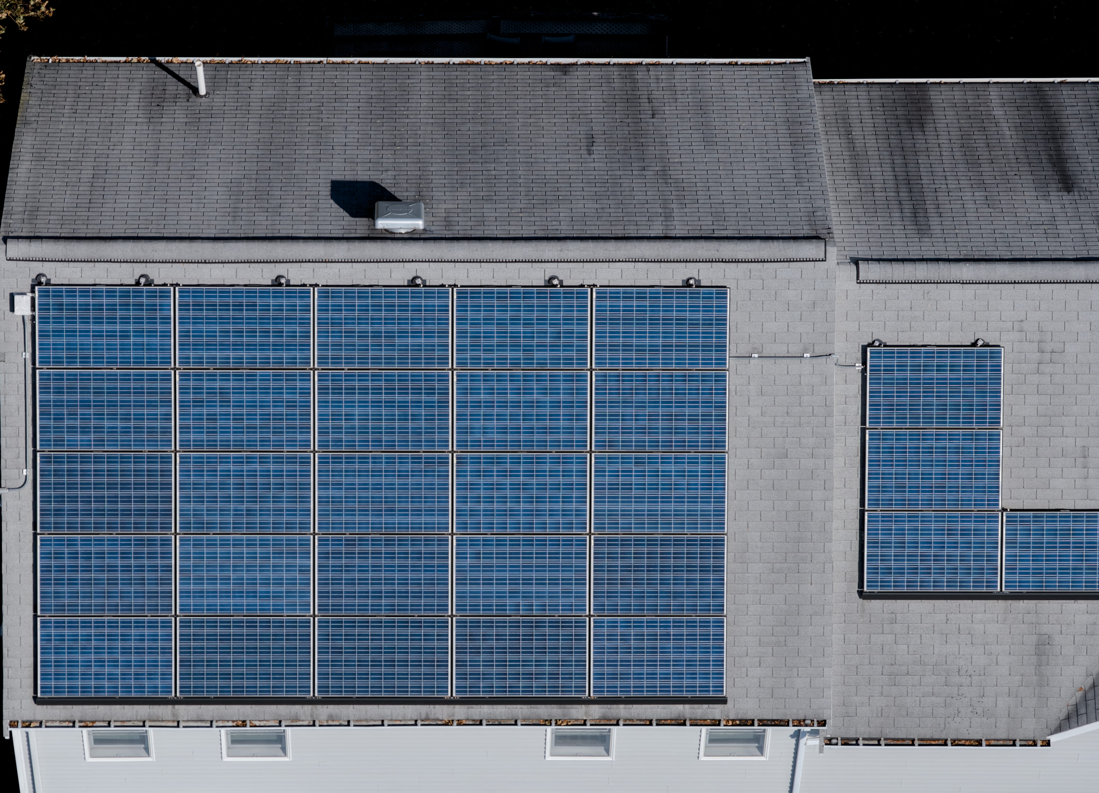 Aerial drone picture featuring solar panels on top of a residential building, used for inspection purposes