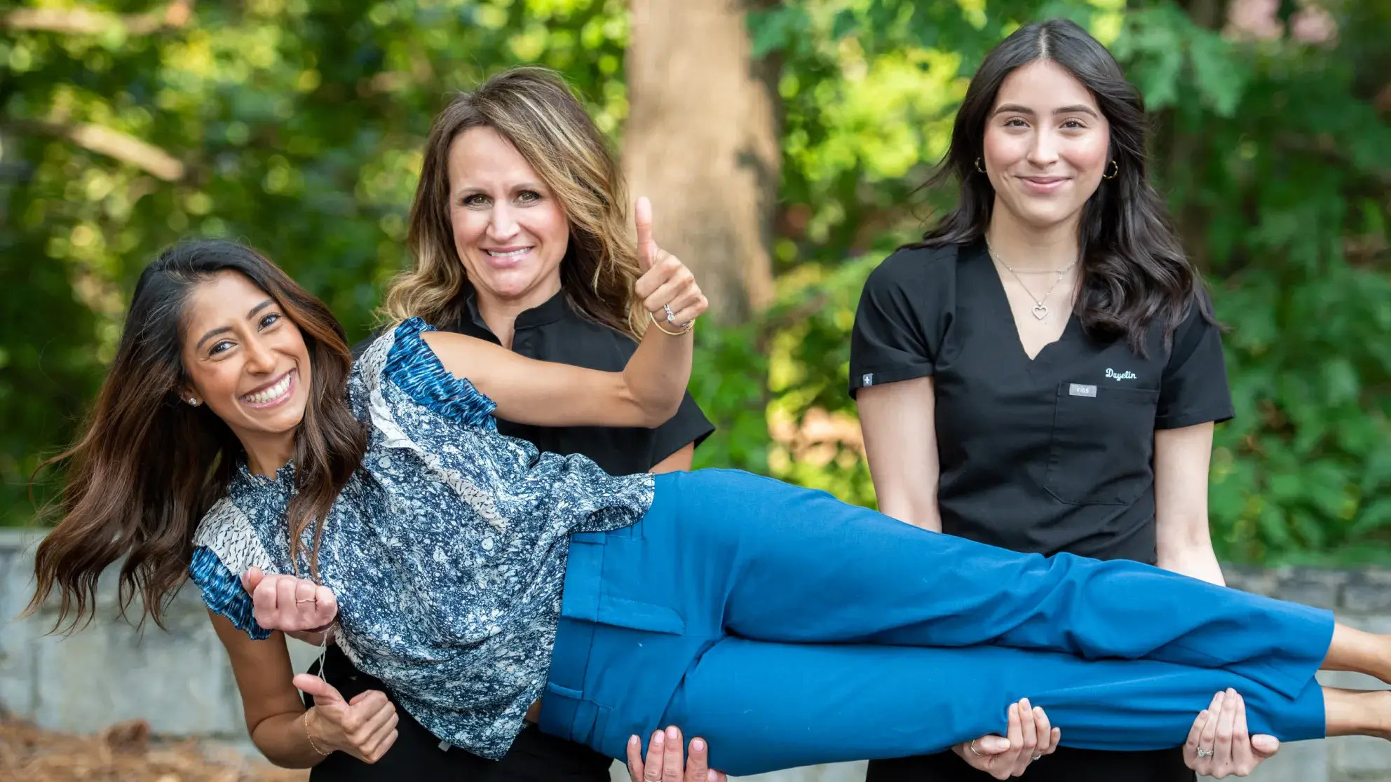 Team members carrying Dr. Cara and smiling