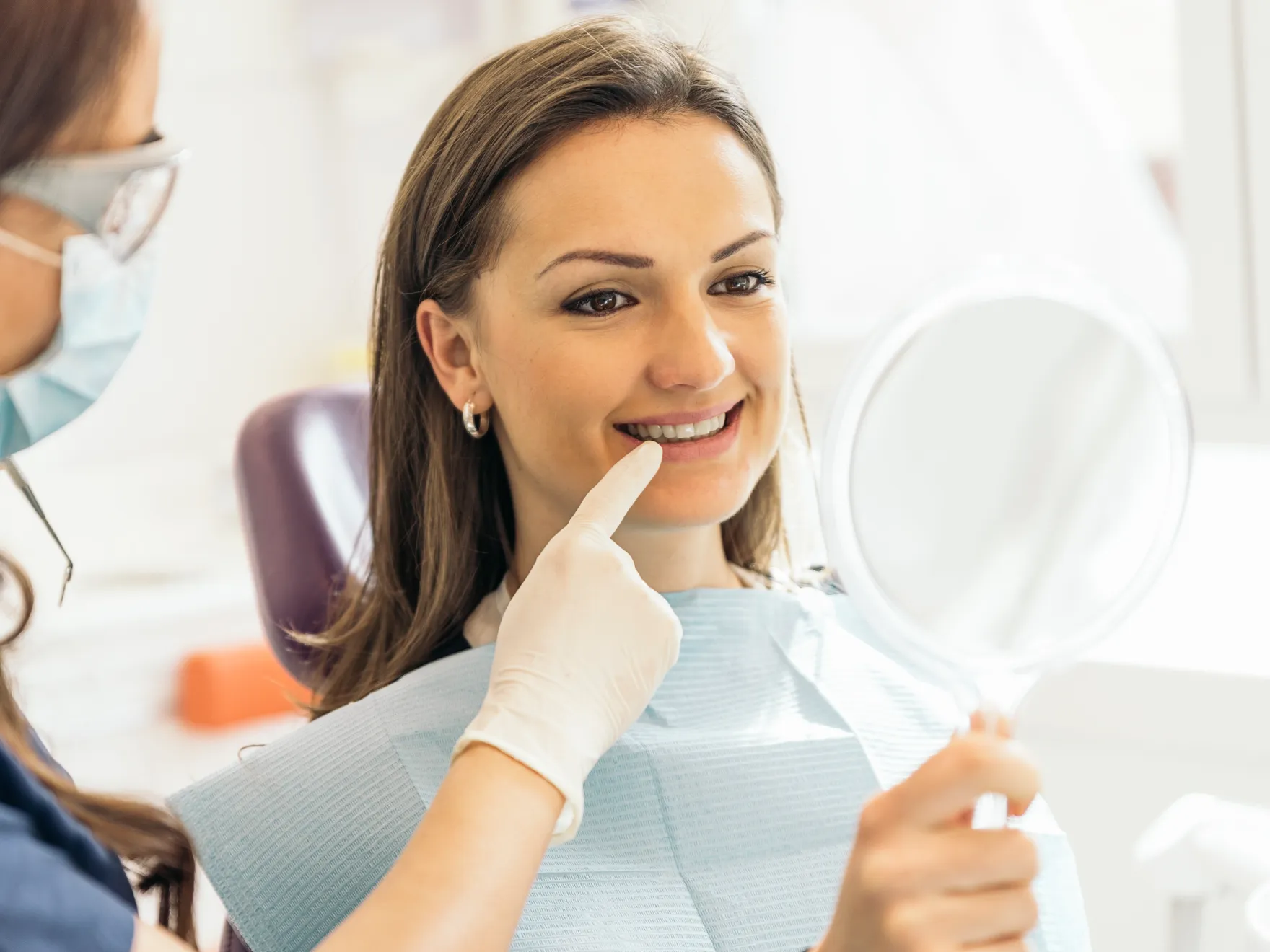 Patient smiling while Dr. shows her dental crowns