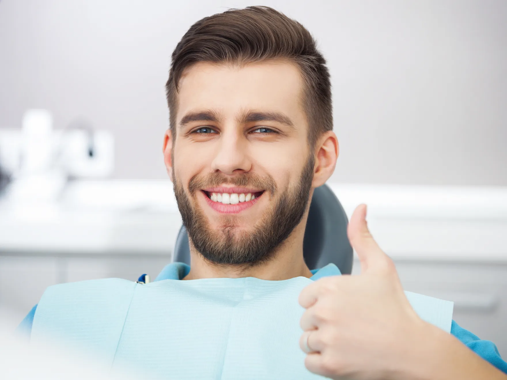 Portrait of happy patient in dental chair.