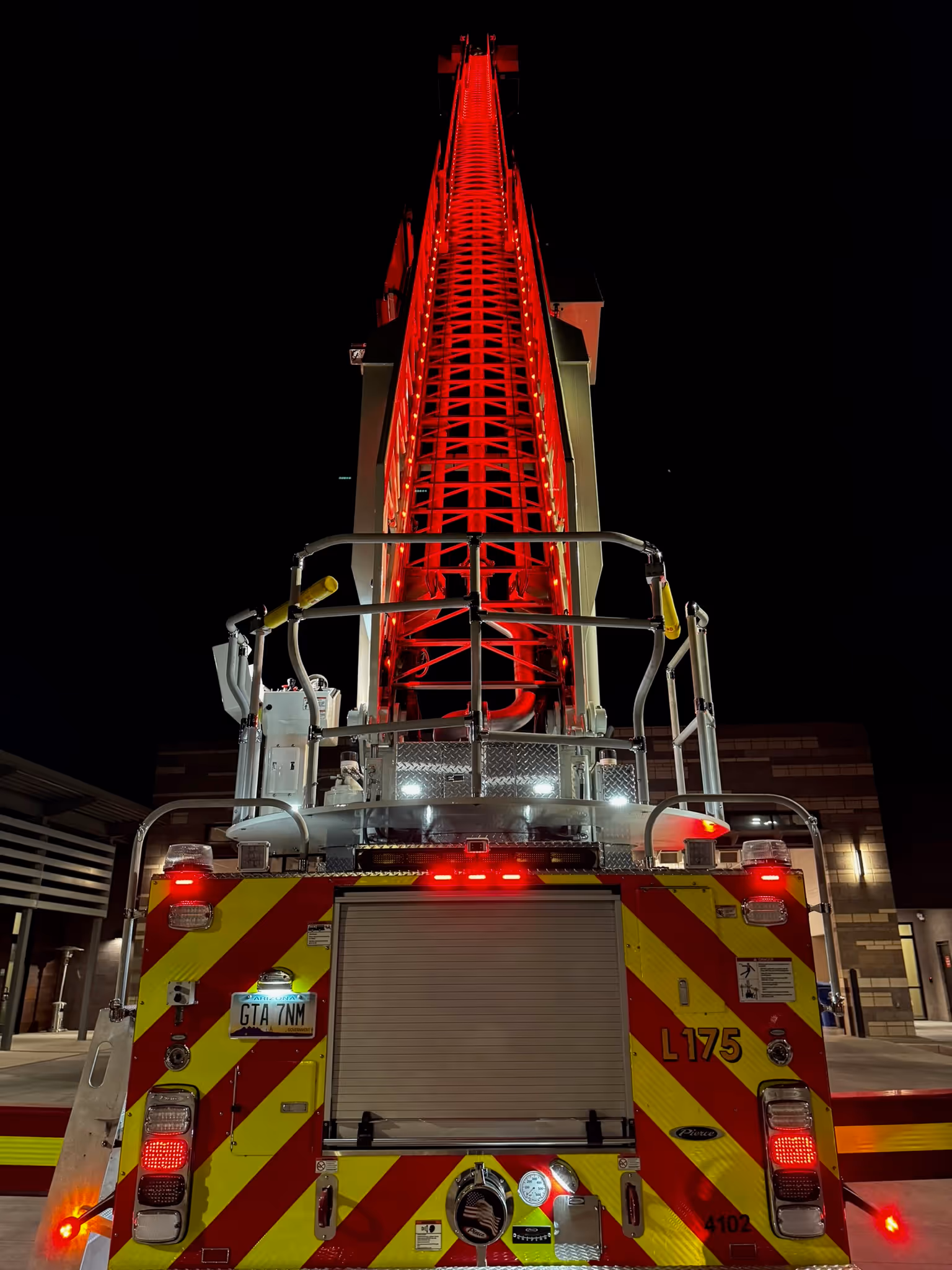 A fire truck with flashing red lights, ready for action, parked on the street.