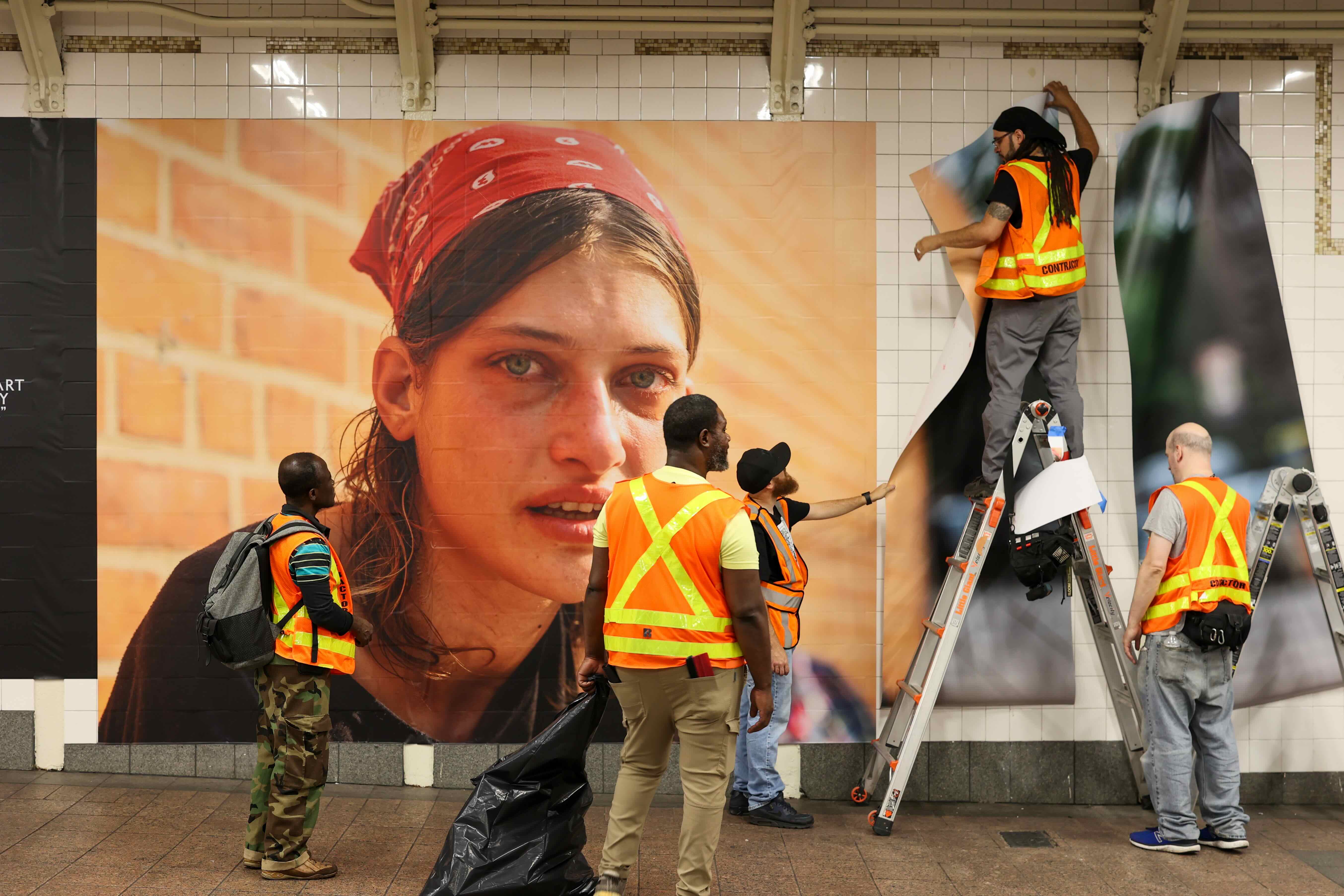 Wall graphics being installed in the subway at Grand Central in preparation for Dear New York, an art installation. 