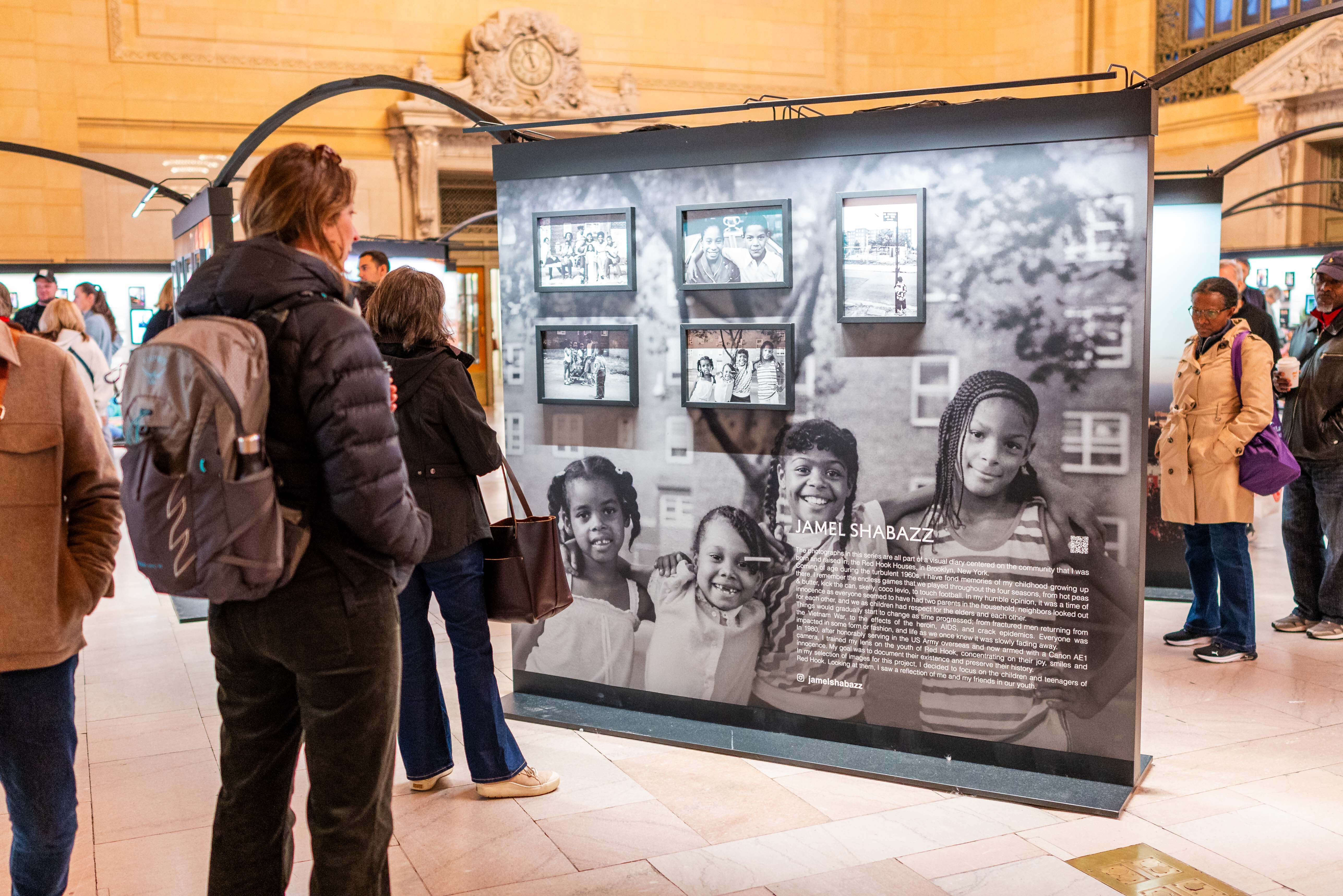 People looking at the exhibit in Vanderbilt Hall, Grand Central during Dear New York, an art installation. 
