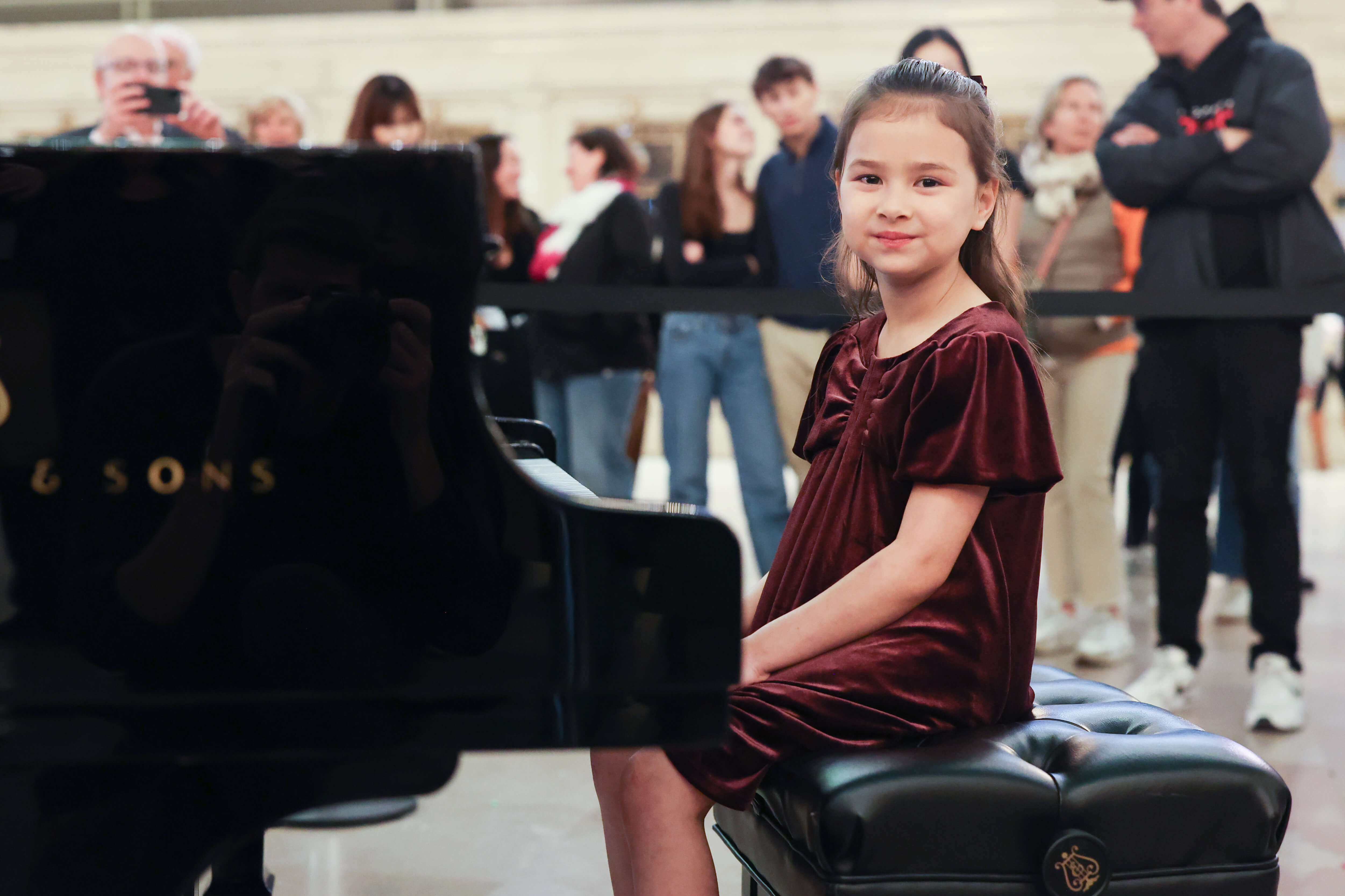 A child posing sat at the Steinway piano during Dear New York, an art installation at Grand Central.