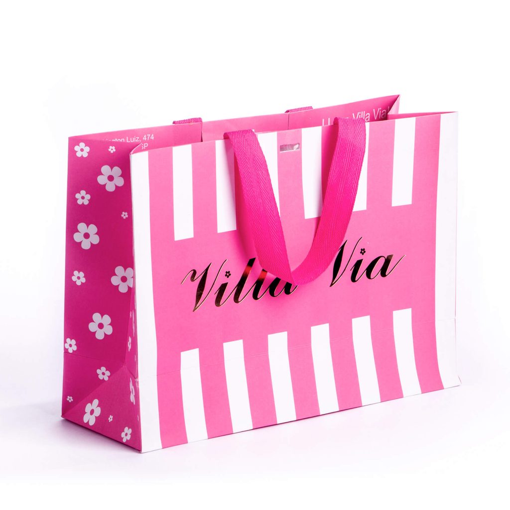 Pink and white striped shopping bag with pink handles and white flower patterns on the side, displaying the text 'Villa Via'.