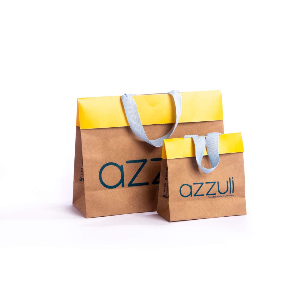 Two brown paper shopping bags with yellow tops and light blue handles, branded with the name 'azzuli'.